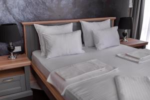 多布拉沃达Baba's Hotel & Spa的一间卧室配有带白色床单和枕头的床。