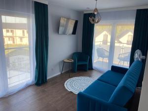 萨比诺瓦Wytworna Foczka的客厅设有蓝色的沙发和大窗户