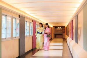 那须盐原市Ooedo Onsen Monogatari Hotel New Shiobara的两个和服上的女人站在走廊上