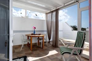 普拉亚布兰卡Casa Maria的客房设有桌椅和窗户。