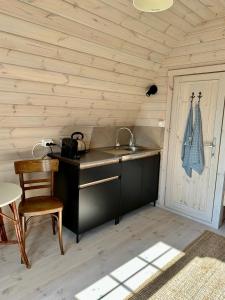 Belt-SchutslootLODGE, een super knus tiny house, nabij vaarwater en haven!的一个带水槽和木墙的厨房