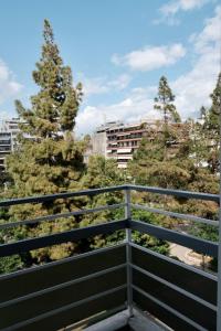 比雷埃夫斯SynPiraeus Apartments & Studios的阳台享有树木和建筑的景致。
