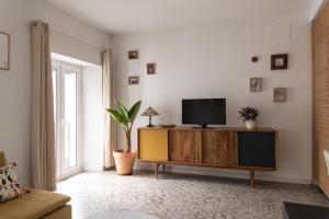罗塔Rosario17 by 7Escalones的客厅配有木柜上的电视
