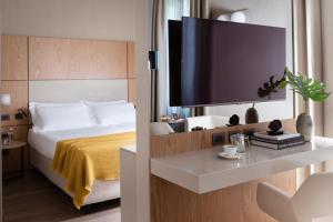 米兰克里斯托佛罗克伦伯世界酒店的配有一张床和一台平面电视的酒店客房