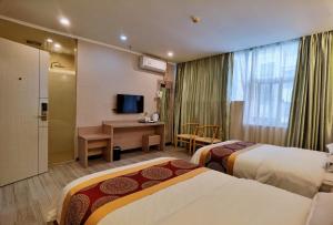 深圳松缘酒店的酒店客房配有两张床和一张书桌
