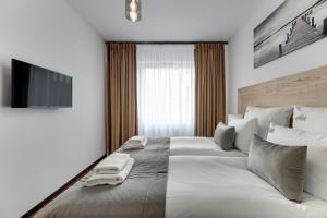 格但斯克Downtown Apartments Seaside Baltea Park & Parking的一间卧室配有一张大床和两条毛巾
