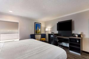 南本德Quality Inn South Bend near Notre Dame的酒店客房配有一张床、一张书桌和一台电视。