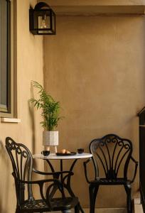 罗希姆诺Casa di Gaga的两把椅子和一张桌子,上面有植物