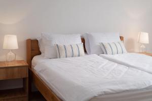 SmokovićSpacious and fully equipped apartment near Zadar的一张带白色床单和枕头的床以及两盏灯