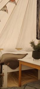 普马拉Luksustelttailua Saimaan Pistohiekalla的帐篷内一间卧室,配有一张床