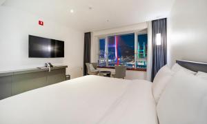 丽水市Yeosu Hotel Haven的配有一张床、一张书桌和一扇窗户的酒店客房