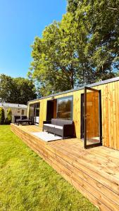 MatslootLuxe Tiny House bij het Leekstermeer的小屋内的大型木甲板,卧室