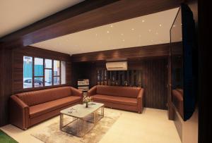 钦奈SUPREME STAY的客厅配有2张棕色沙发和1张桌子
