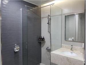 华城市Hotel Ciel Dongtan的一间带玻璃淋浴和水槽的浴室