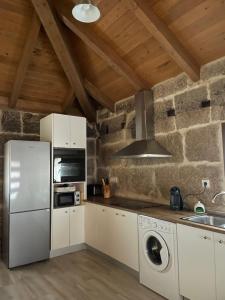 As Fontaiñas的一间厨房,配有白色家电和石墙
