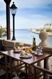 休达德亚卡拉博纳玛尔布拉法酒店的一张桌子,上面放着两盘食物和一杯橙汁
