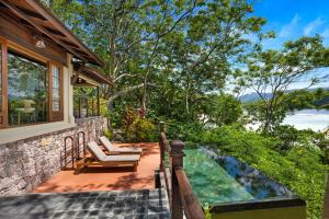 Round IslandJA Enchanted Island Resort Seychelles的一个带椅子的庭院和一个位于房子内的游泳池