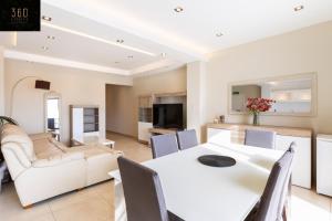 圣朱利安斯Beautiful, spacious 3BR home with private Balcony with 360 Estates的用餐室以及带白色桌椅的起居室。