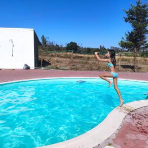 奥利维拉多霍斯比托Vila da Laje - Onde a Natureza o envolve - Serra da Estrela的跳进游泳池的年轻女孩