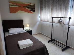 马科普隆A&J Apartments or Rooms athens airport的一间卧室配有一张床,上面有两条毛巾