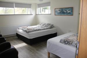 KiðagilLjósavatn Guesthouse的一间卧室设有两张床和两个窗户。