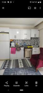 马尔马拉Avşa kiralık yazlık ev的厨房配有白色橱柜和红色沙发