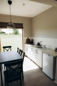 DurbeDurbes Atvari - brīvdienu mājas ar saunu的厨房配有白色橱柜和桌椅