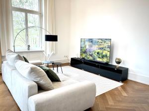 威斯巴登Palais Passy~Design Suite mit Ausblick im Zentrum的带沙发和电视的白色客厅