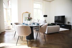 威斯巴登Palais Passy~Design Suite mit Ausblick im Zentrum的客厅配有桌椅和沙发