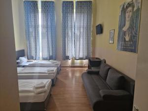 柏林斯图加特爱客姆酒店 的带三张床和一张沙发的房间