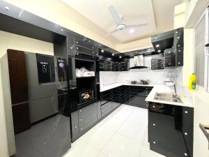 伊斯兰堡LUXURY 6 Bedroom Holiday Home的黑白厨房配有黑电器