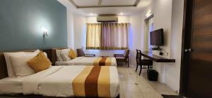艾哈迈达巴德Hotel Kanak的酒店客房配有两张床和一张书桌