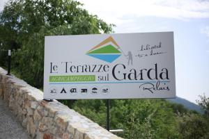 BiazaLE TERRAZZE SUL GARDA RELAIS的石墙旁读温带花岗岩的标志