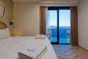 巴统MiraMar Luxury Residences的酒店客房设有两张床和大窗户。