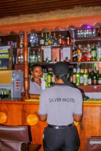 基加利SILVER HOTEL APARTMENT Near Kigali Convention Center 10 minutes的站在酒吧前的人