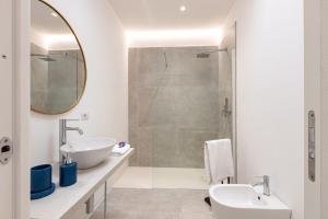 奥尔比亚Baia del Sole的白色的浴室设有水槽和淋浴。