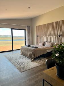 雷克霍特Luxury villa with hot tub & amazing view的一间卧室设有一张大床和一个大窗户