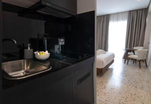 雅典Mythodea Athens Suites的一个带水槽的厨房和一张位于客房内的床