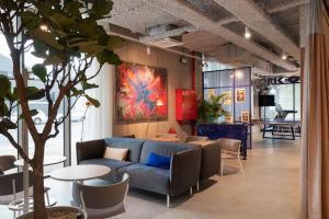 根特Adagio Access Gent Centrum Dampoort的客厅配有蓝色的沙发、桌子和椅子