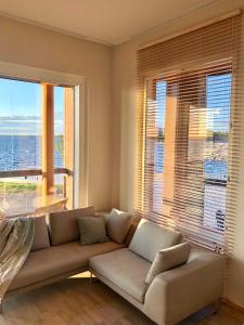 坦佩雷Upea kohde Näsijärven rannassa的带沙发和大窗户的客厅