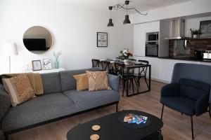 贝尔热拉克Le Pozzi, parking privé plein centre的客厅配有灰色的沙发和桌子