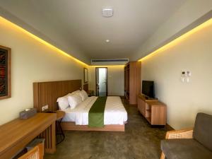 马塔兰Ayom Suite的酒店客房,配有床和电视