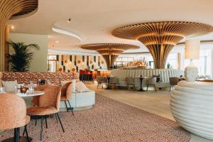 贝斯特Van der Valk Hotel Eindhoven-Best的酒店大堂设有桌椅和酒吧
