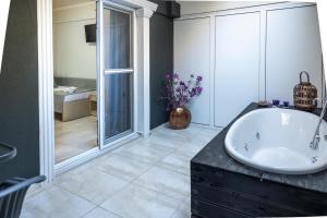 奥林匹亚基·阿克蒂R&M STUDIOS的浴室配有白色浴缸和水槽