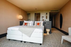 贝斯特Van der Valk Hotel Eindhoven-Best的卧室配有带橙色枕头的大型白色床