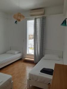 伊奥斯乔拉Zinas pension的客房设有两张床和窗户。
