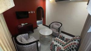 哈费尔巴廷Al Mansour Grand Hotel的客厅配有两把椅子和一张桌子