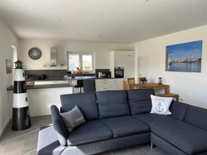 比苏姆Ferienhaus RELAX的一间带蓝色沙发的客厅和一间厨房