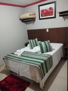 多拉杜斯Turis Hotel的一间卧室配有一张床,床上有条纹毯子