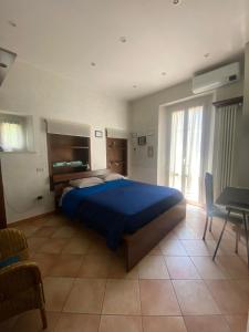 佩萨罗皮吉奥托酒店的一间卧室配有一张蓝色的大床和一张桌子